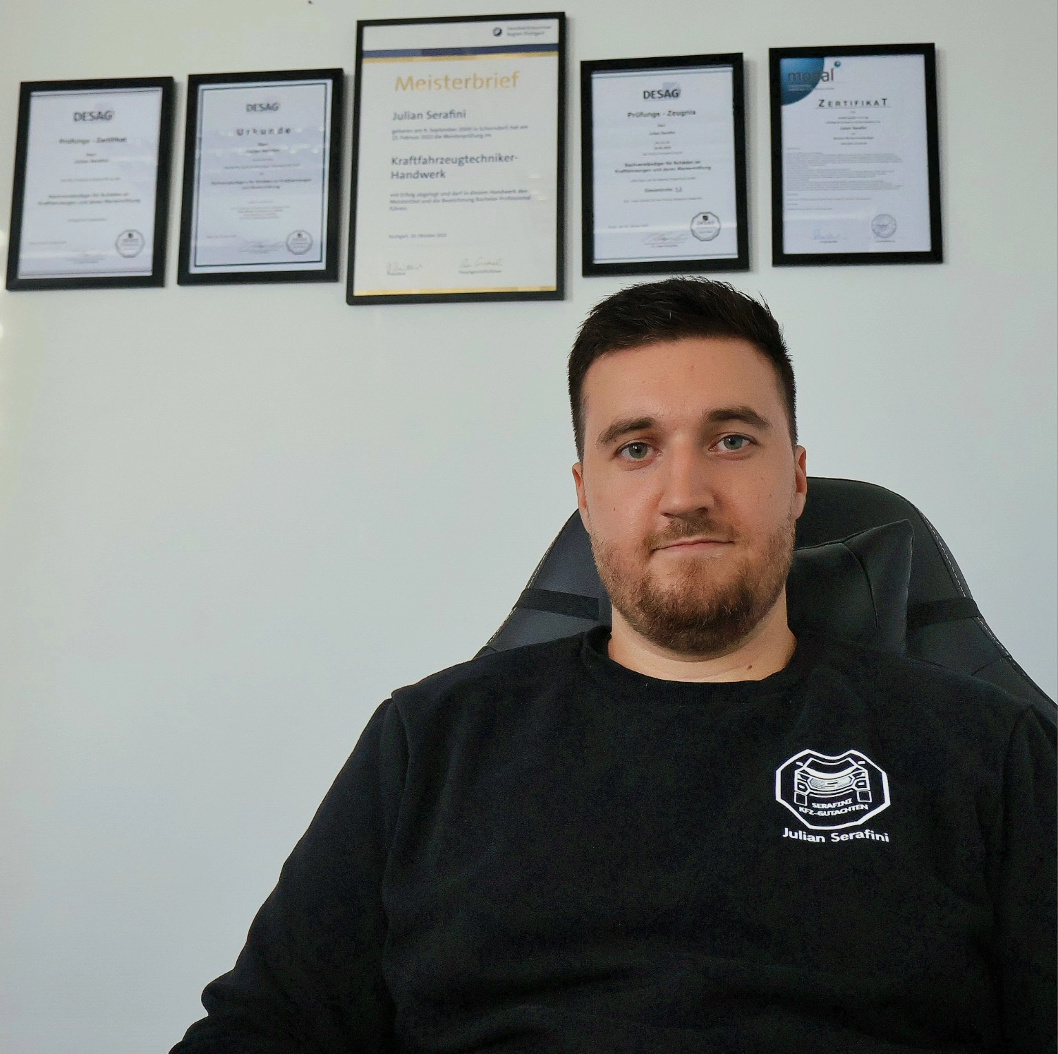Julian Serafini, Kfz-Technikermeister und Kfz-Sachverständiger, vor seinen Qualifikationsnachweisen